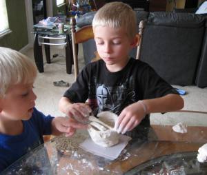 Little C and Little R working with clay.  What started out as a pyramid project, turned into clay coil pots...lol!